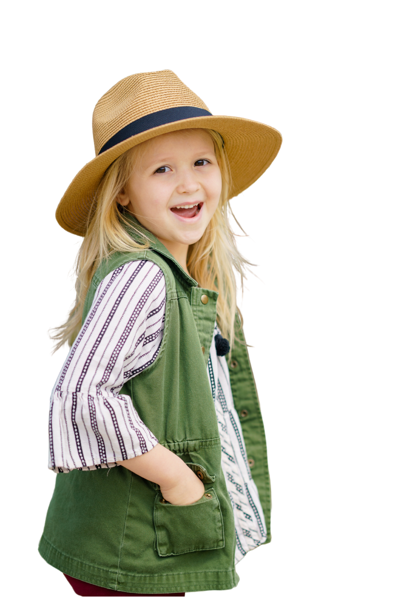 girl in a hat stands and smiles