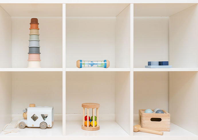 toys arranged on white shelves made of wood