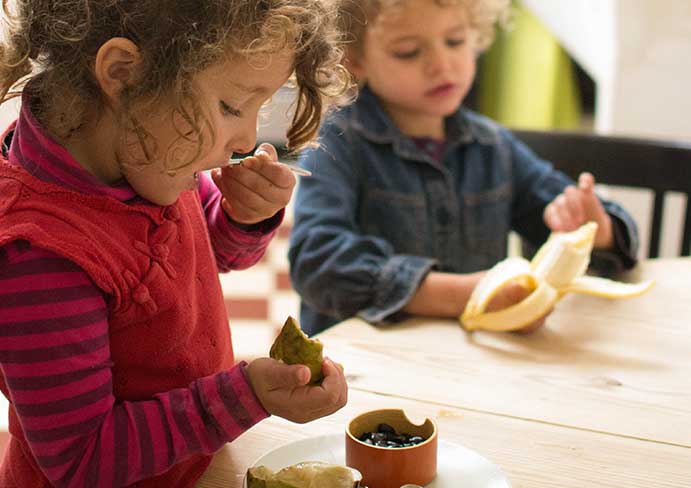 children eat fruit at the table